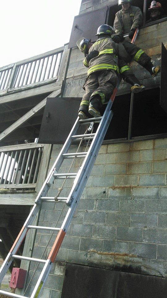 Firefighter at the Top of a Ladder Carrying Another Firefighter